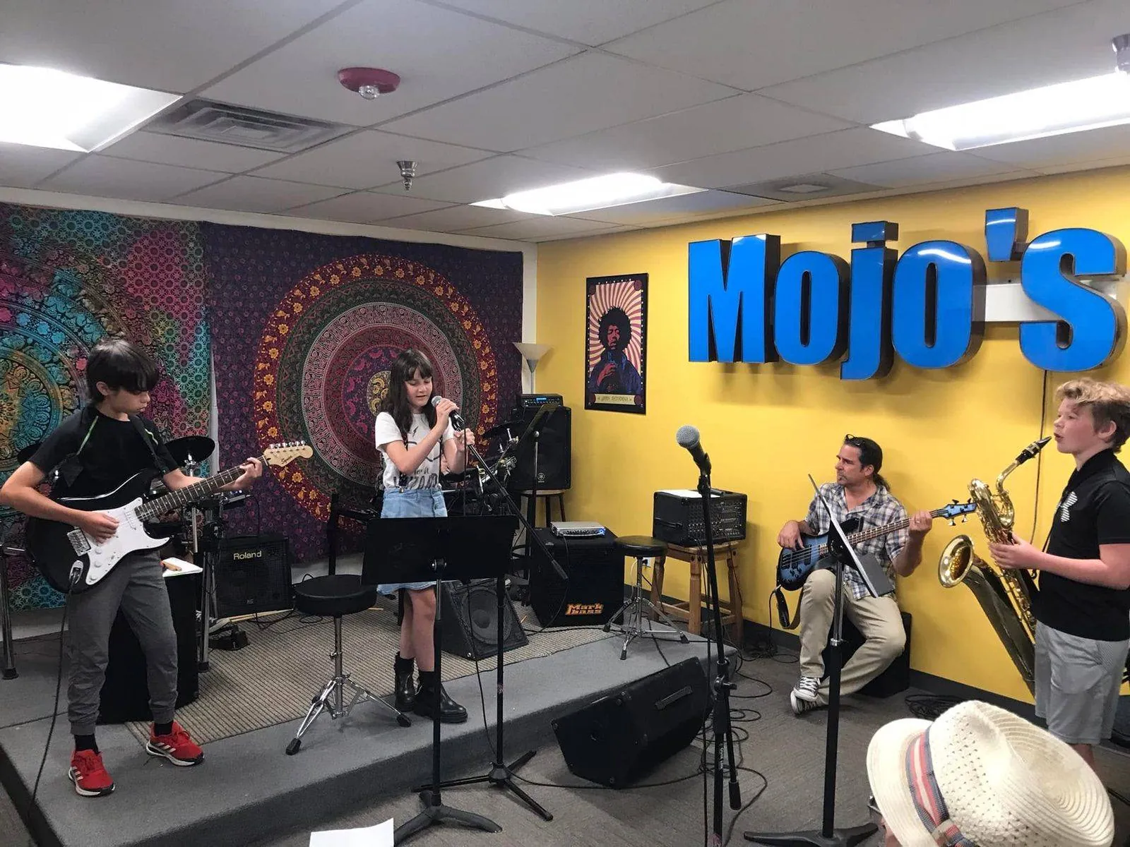 A full band of Mojo's students performing together on stage at a recital