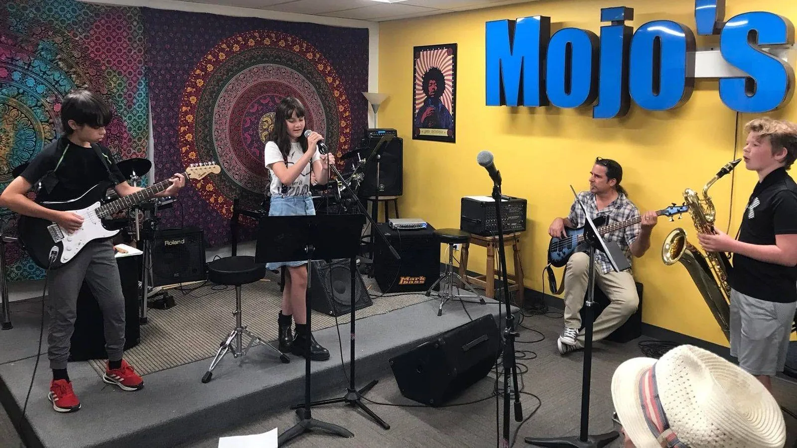 A full band of Mojo's students performing together on stage at a recital