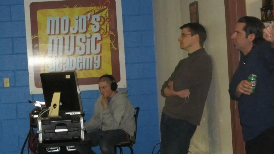 A candid moment at Mojo's Music Academy, in front of the studio sign
