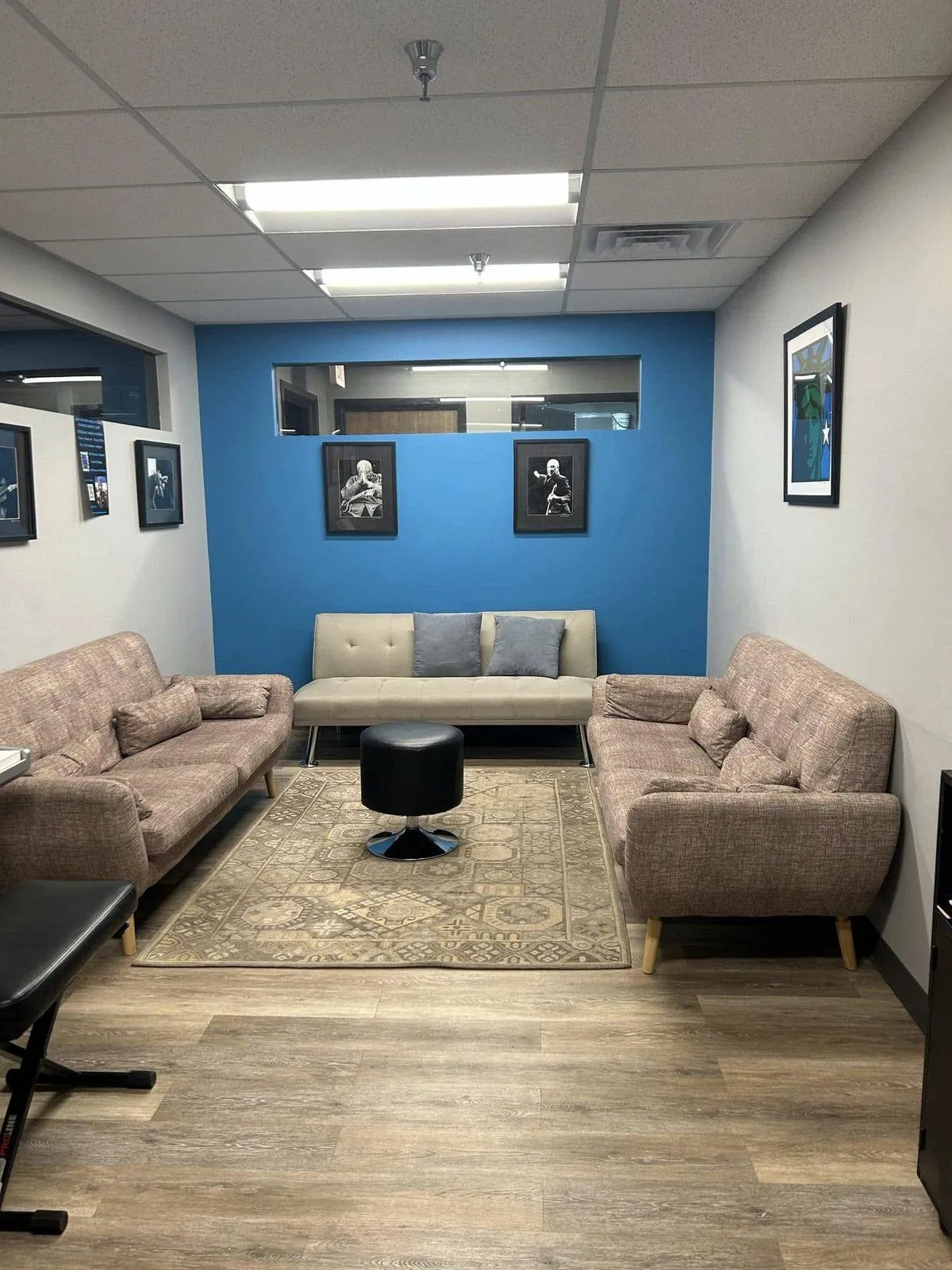 A second seating area with sofas and a rug at Mojo's Music Academy, for parents and students waiting during lessons