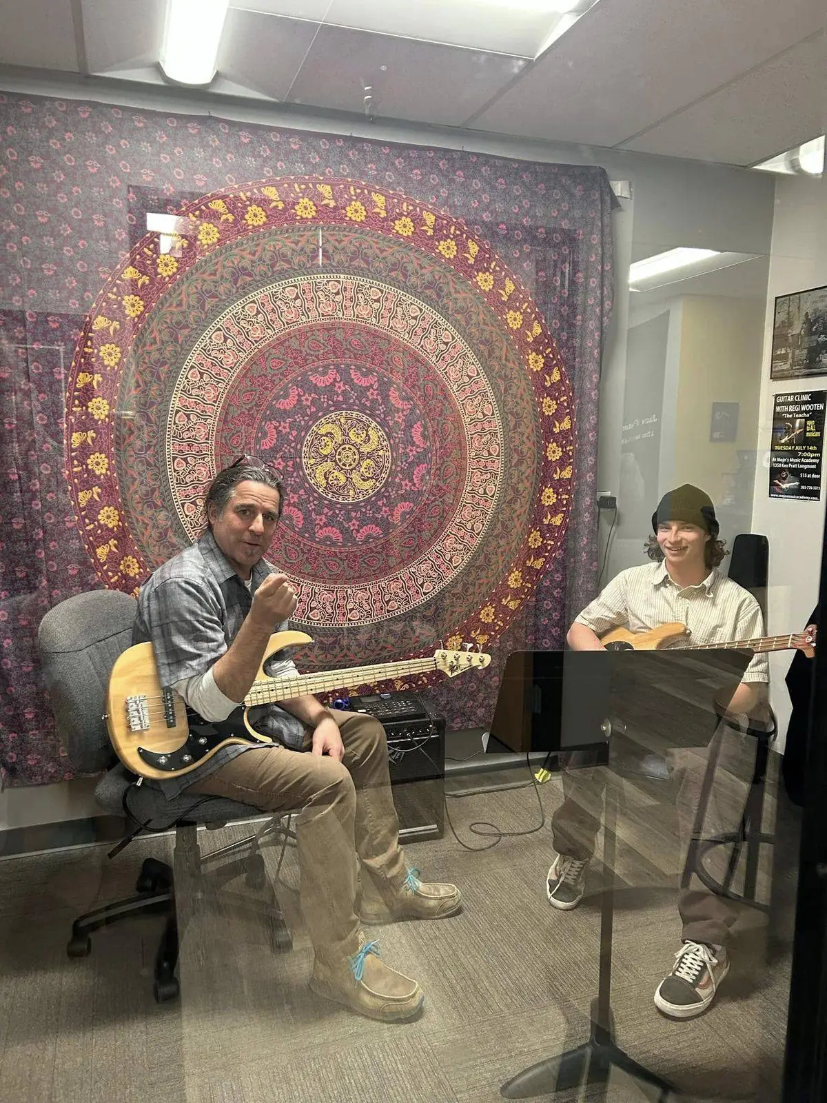 An instructor and student playing bass guitar together in a private lesson room at Mojo's Music Academy