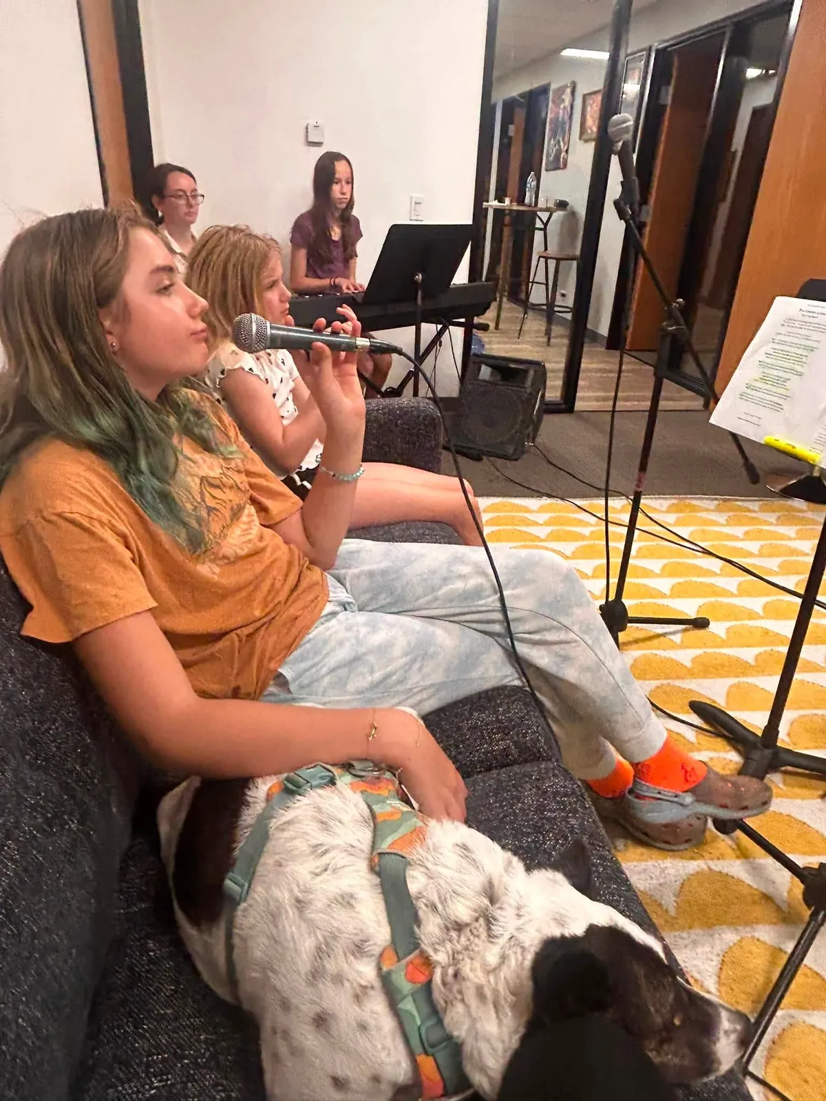 Students and Koko, the Mojo's Music Academy mascot, relaxing on the rehearsal room couch during a break