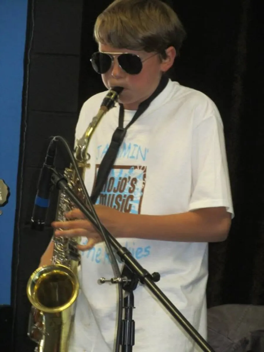 Student playing saxophone at a Mojo's Music Academy performance