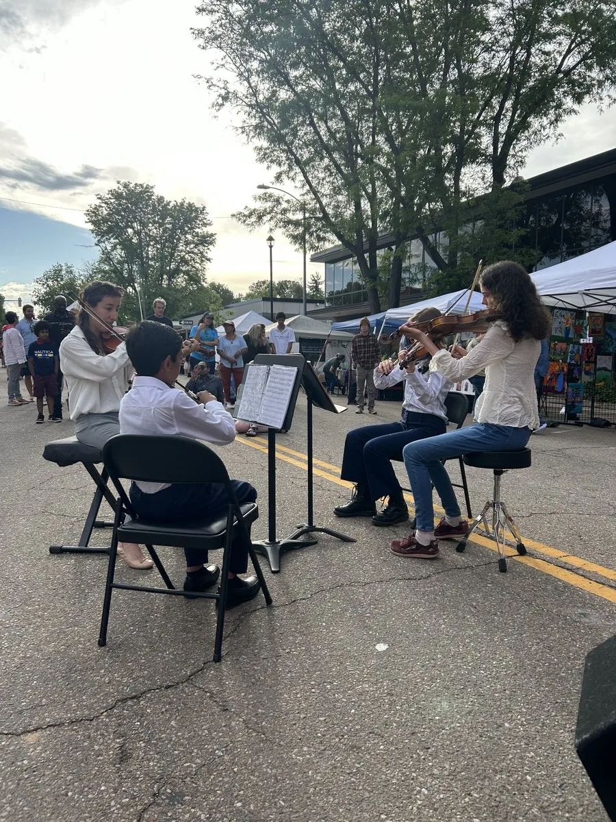 Mojo's Music Academy string students performing together outdoors in Longmont, CO