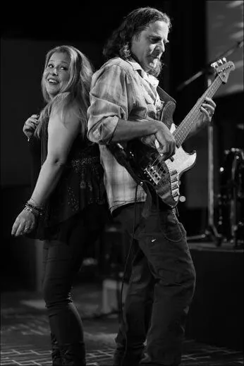 Jessica and Paul Rogalski performing together on stage, founders of Mojo's Music Academy in Longmont, CO
