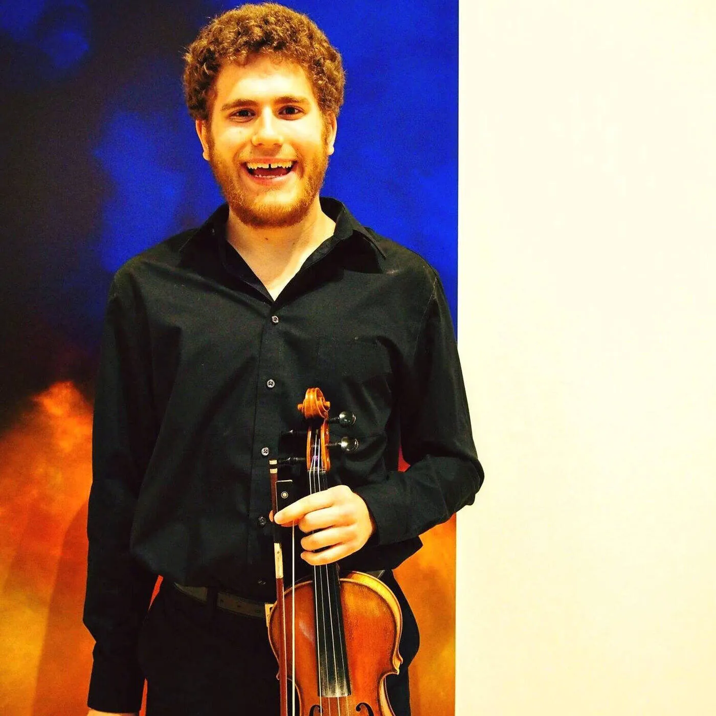 Jacob Rothstein holding a violin, fiddle and piano instructor at Mojo's Music Academy in Longmont, CO