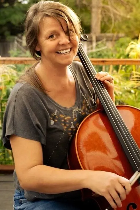 Nicole Bernard holding a cello, cello instructor at Mojo's Music Academy in Longmont, CO