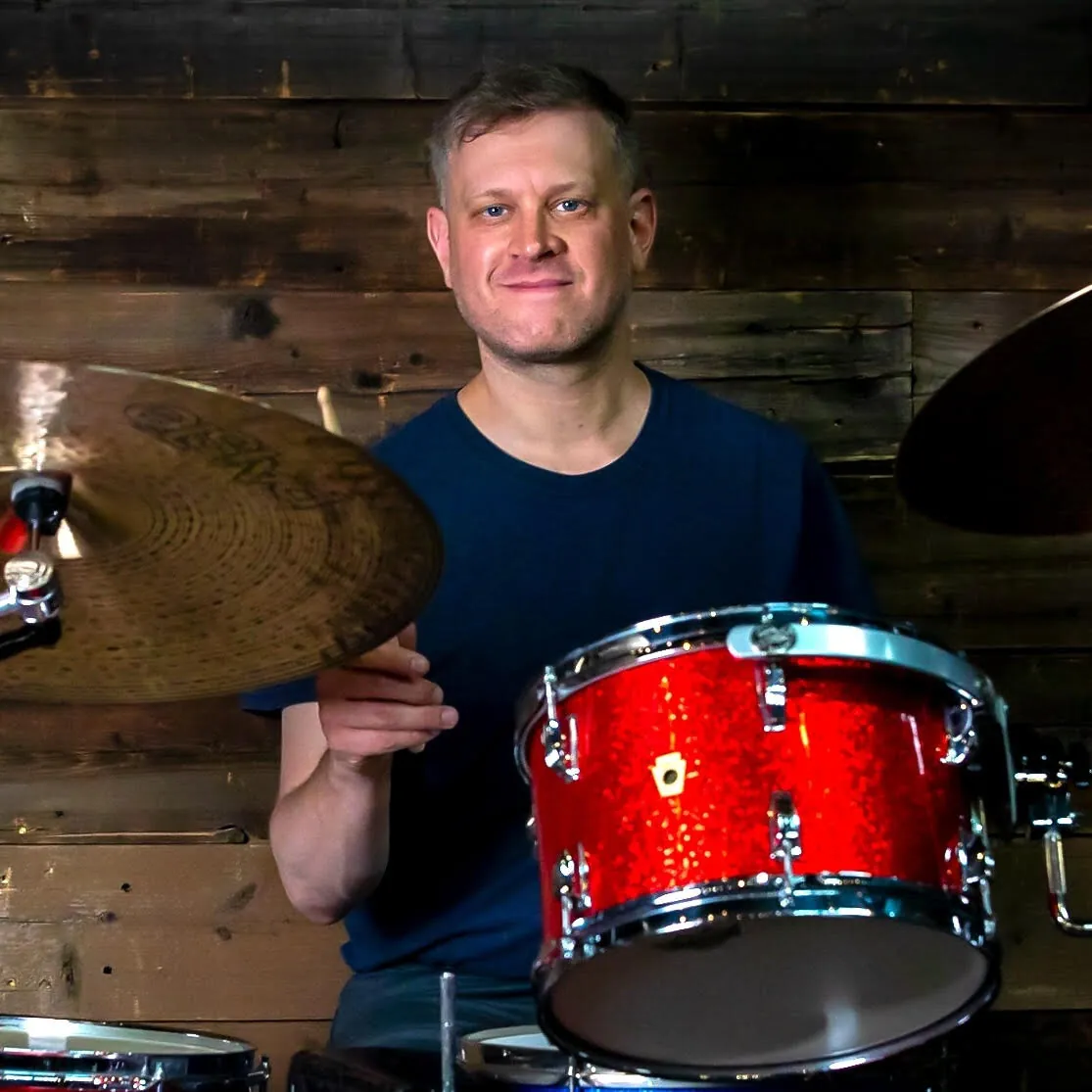 Ryan Elwood behind a drum kit, drum instructor at Mojo's Music Academy in Longmont, CO